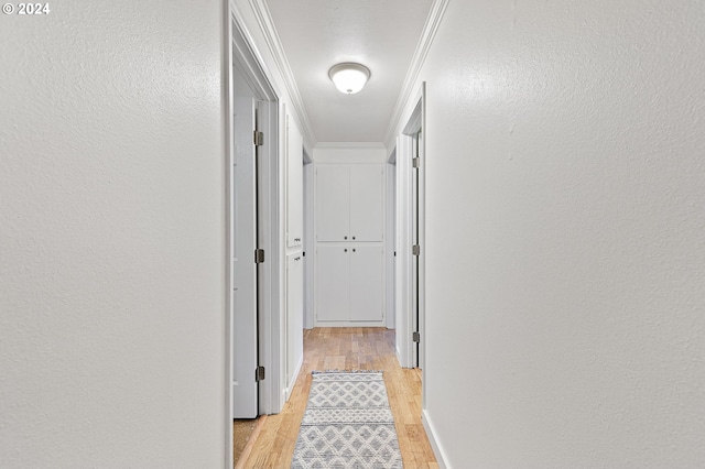 hall with light wood-type flooring and crown molding