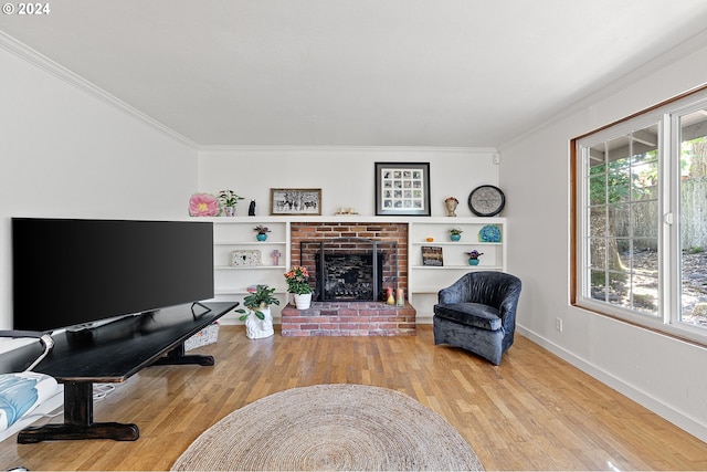 living room featuring light wood-type flooring, a brick fireplace, and crown molding