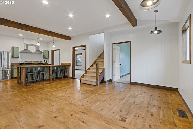 interior space with light wood-type flooring and beam ceiling