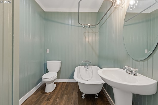 bathroom with sink, a washtub, toilet, and hardwood / wood-style flooring