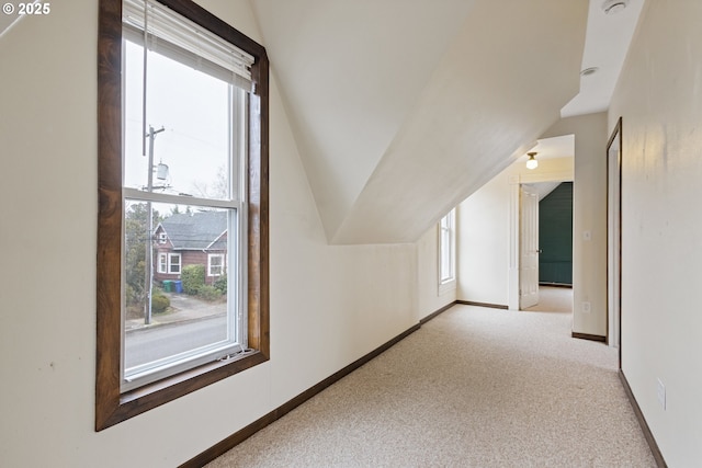 bonus room featuring vaulted ceiling and light carpet