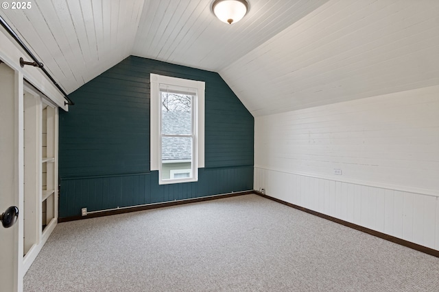 additional living space featuring carpet floors and vaulted ceiling