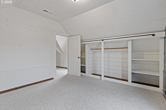 unfurnished bedroom featuring lofted ceiling, light colored carpet, and a closet