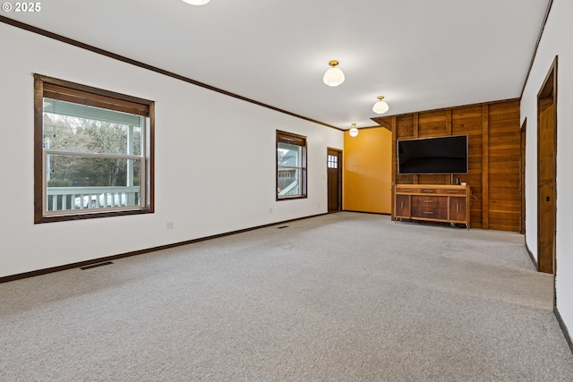 unfurnished living room featuring light colored carpet and crown molding