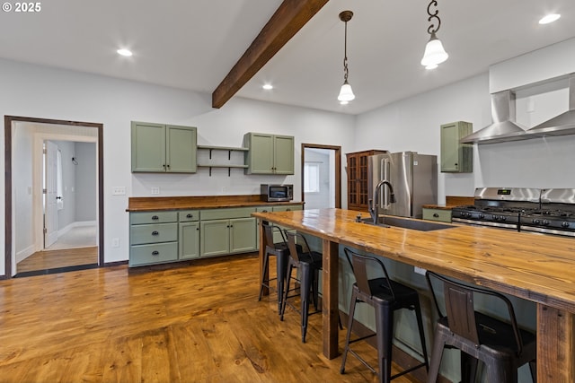 kitchen featuring wooden counters, stainless steel appliances, pendant lighting, and green cabinets