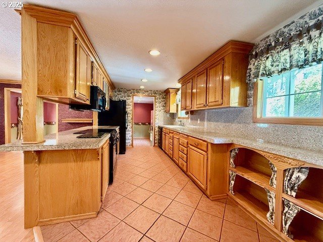 94504 Smokey Ln, Coquille, OR 97423 - kitchen featuring black appliances, recessed lighting, light tile patterned flooring, brown cabinets, and backsplash