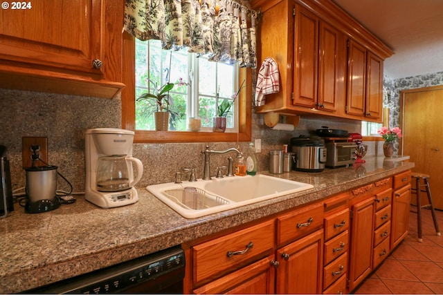 kitchen with backsplash, black dishwasher, light tile patterned flooring, and sink