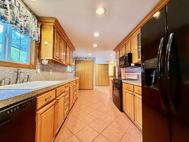 94504 Smokey Ln, Coquille, OR 97423 - kitchen with light tile patterned floors, light countertops, black appliances, decorative backsplash, and a sink