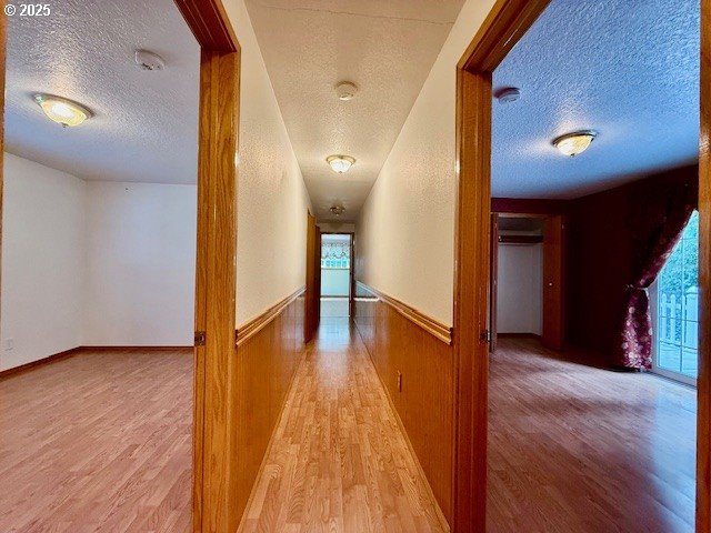 94504 Smokey Ln, Coquille, OR 97423 - hallway featuring a wealth of natural light, wood finished floors, and a textured ceiling