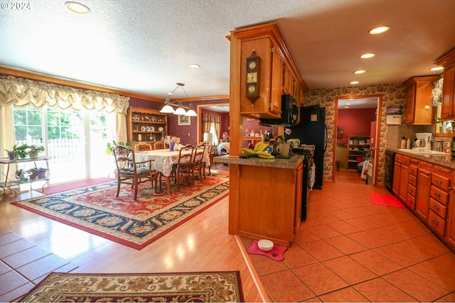 kitchen with sink, kitchen peninsula, crown molding, pendant lighting, and a textured ceiling