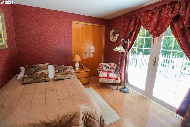 bedroom featuring hardwood / wood-style flooring, access to outside, and french doors