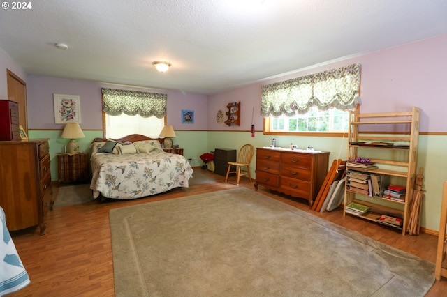 bedroom featuring wood-type flooring and a textured ceiling