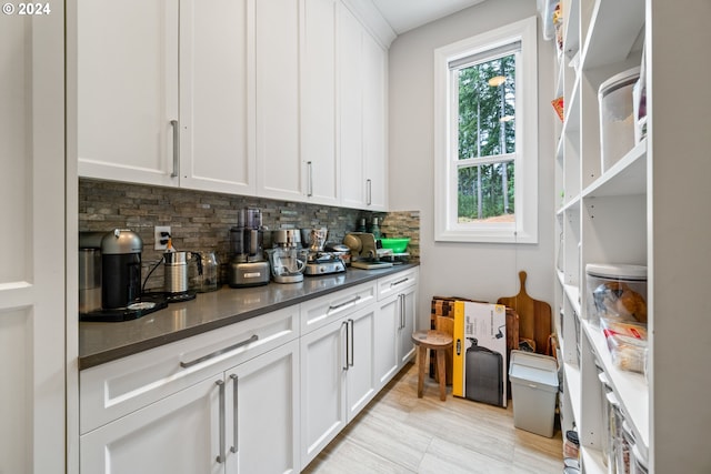 bar with white cabinets and decorative backsplash