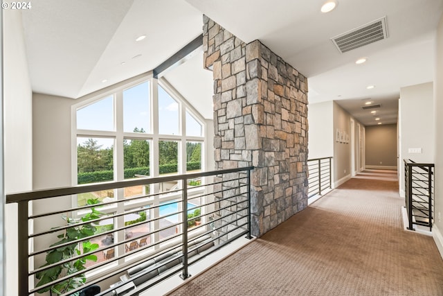 hallway featuring carpet floors and vaulted ceiling with beams