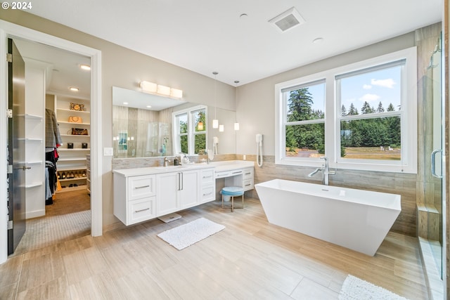 bathroom with vanity, tile walls, and independent shower and bath