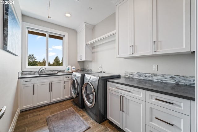 washroom with cabinets, separate washer and dryer, and sink