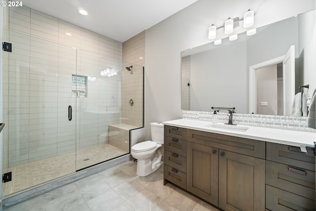 bathroom with a shower with shower door, toilet, vanity, and tasteful backsplash