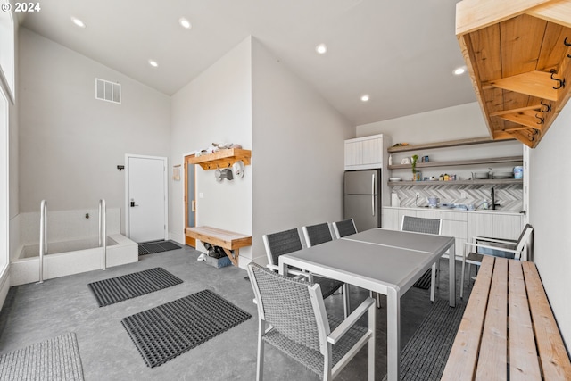 dining space with high vaulted ceiling