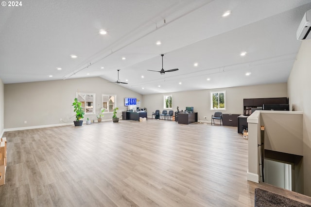 unfurnished living room with light wood-type flooring, ceiling fan, a wall mounted AC, and vaulted ceiling