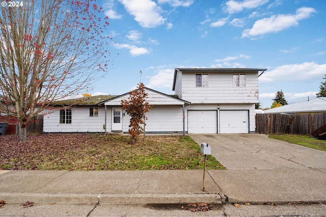 view of front of property with a garage, fence, a front lawn, and concrete driveway