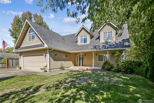 cape cod house featuring a front yard and a garage