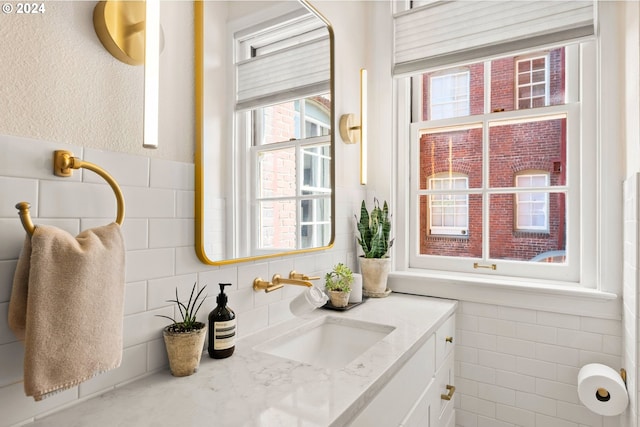 bathroom featuring vanity and tile walls