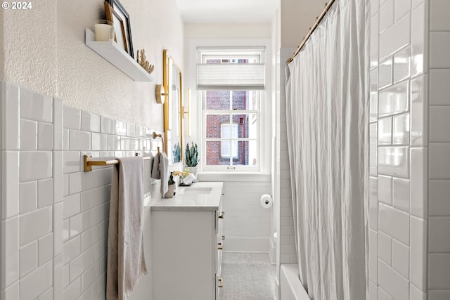 bathroom featuring vanity, tile walls, and shower / tub combo with curtain