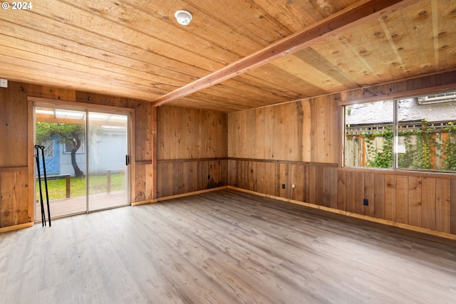 empty room with wood walls, wood ceiling, and hardwood / wood-style flooring