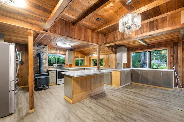 kitchen with stainless steel fridge, wood ceiling, wooden walls, electric stove, and a center island