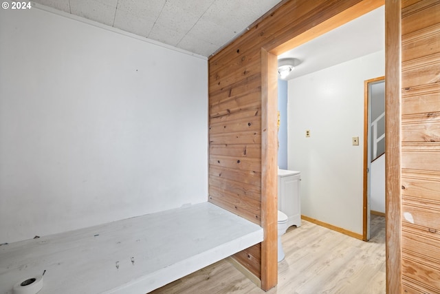 bathroom with wood walls and wood-type flooring