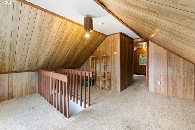 bonus room featuring wood walls, carpet, and lofted ceiling