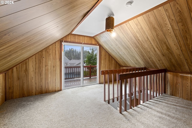 additional living space with carpet, wooden ceiling, vaulted ceiling, and wooden walls