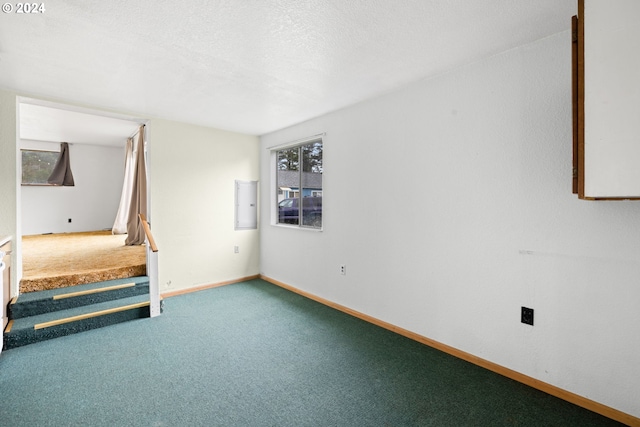 carpeted spare room featuring a textured ceiling