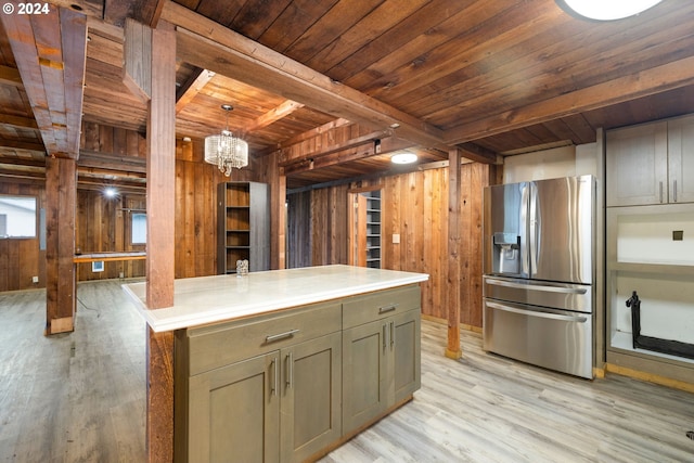 kitchen with stainless steel refrigerator with ice dispenser, wood ceiling, wooden walls, beam ceiling, and a kitchen island