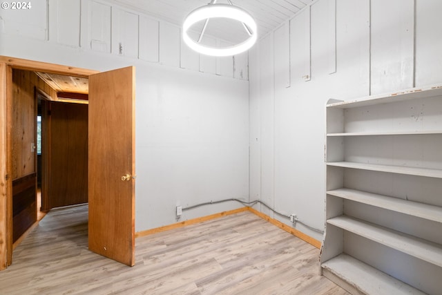 interior space with wood walls and light hardwood / wood-style flooring