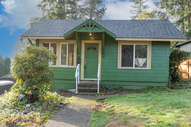 view of front of home featuring cooling unit and a front yard