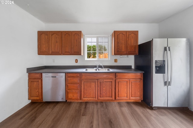 kitchen with stainless steel appliances, sink, and dark wood-type flooring