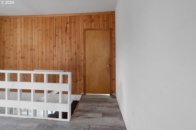 unfurnished bedroom featuring wooden walls and dark hardwood / wood-style floors