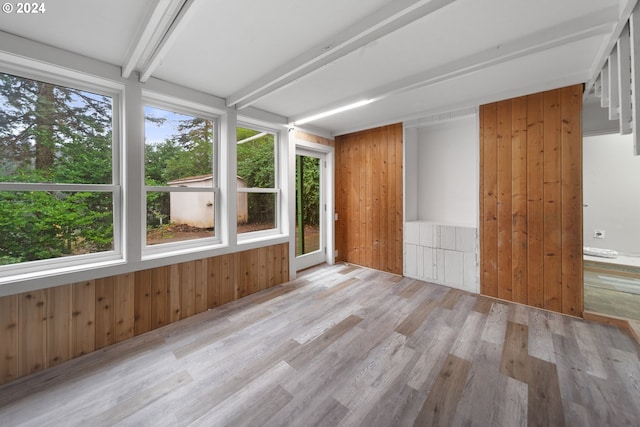 unfurnished sunroom featuring beamed ceiling