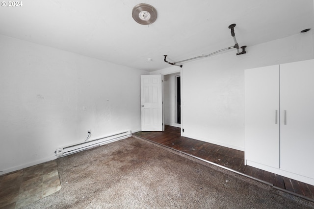 interior space featuring baseboard heating and dark hardwood / wood-style floors