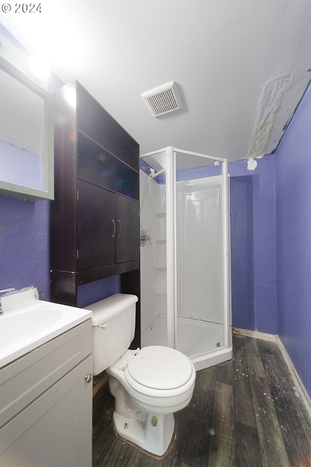 bathroom featuring hardwood / wood-style floors, vanity, toilet, and a shower