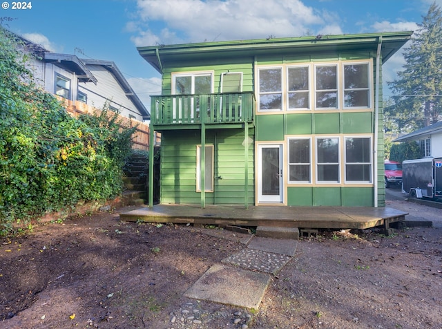 rear view of house featuring a deck and a balcony