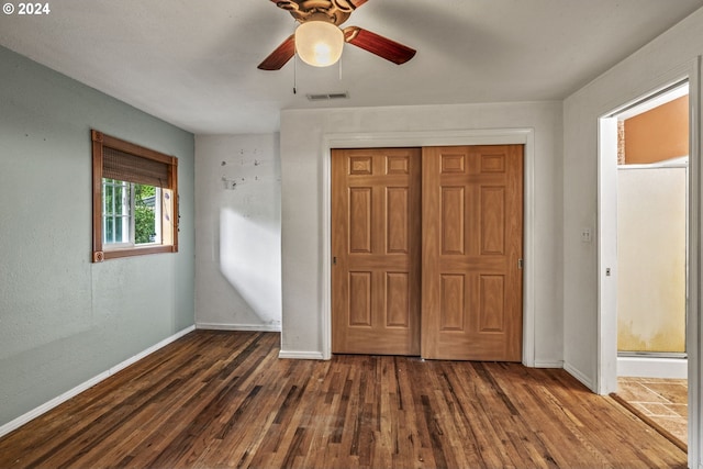 unfurnished bedroom featuring a closet, ceiling fan, and dark wood-type flooring