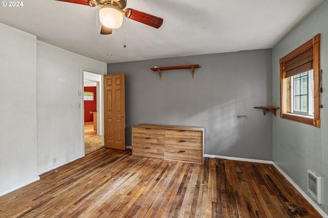 empty room with ceiling fan and dark hardwood / wood-style flooring