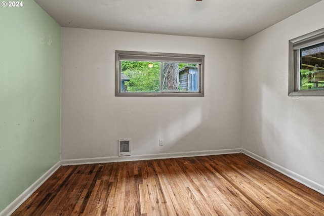 spare room featuring a wealth of natural light and dark hardwood / wood-style flooring