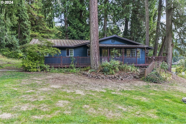 view of front of home with a front yard and a wooden deck