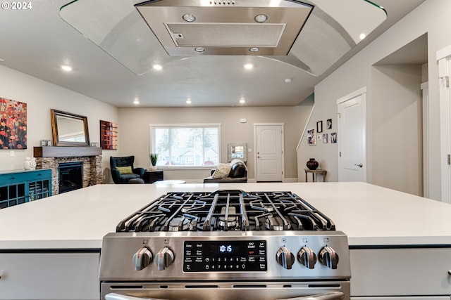 3763 Rockcress Rd, Eugene, OR 97403 - kitchen featuring stainless steel gas range oven, open floor plan, recessed lighting, a stone fireplace, and light countertops