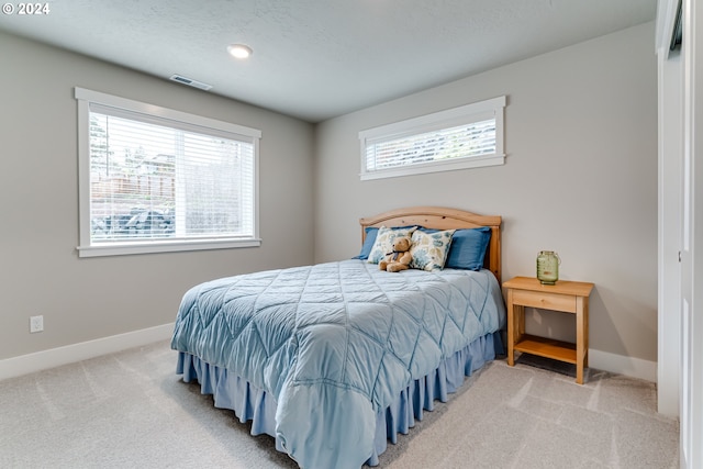 carpeted bedroom featuring multiple windows