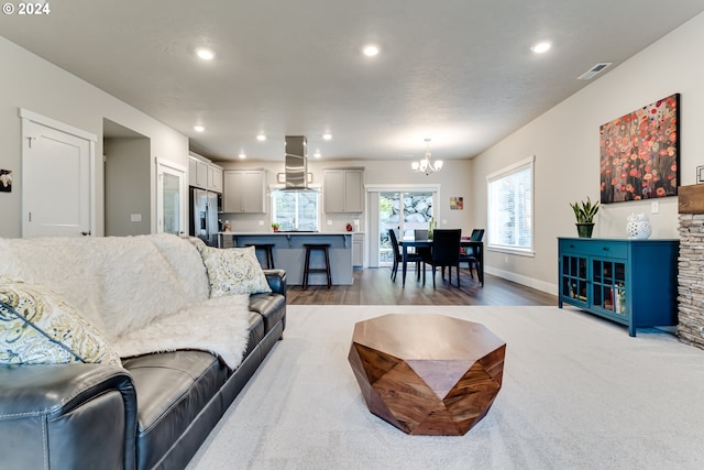 living room with wood-type flooring and a notable chandelier