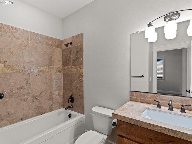 full bathroom featuring vanity, tiled shower / bath combo, and toilet